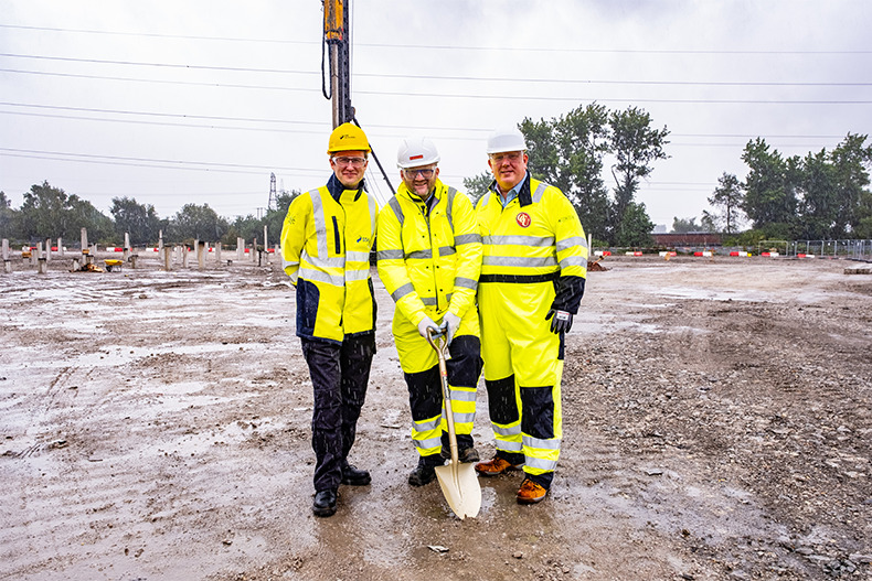 Three SSE representatives in high-visibility workwear put a shovel in the ground to inauguration construction. 