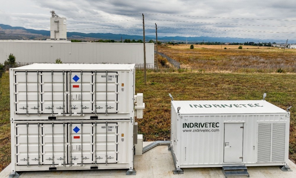 Two containerised 20ft NGK sodium-sulfur (NAS) battery systems stacked on top of one another, next to a container housing inverter equipment, at the site in Kostinbrod, Bulgaria. 