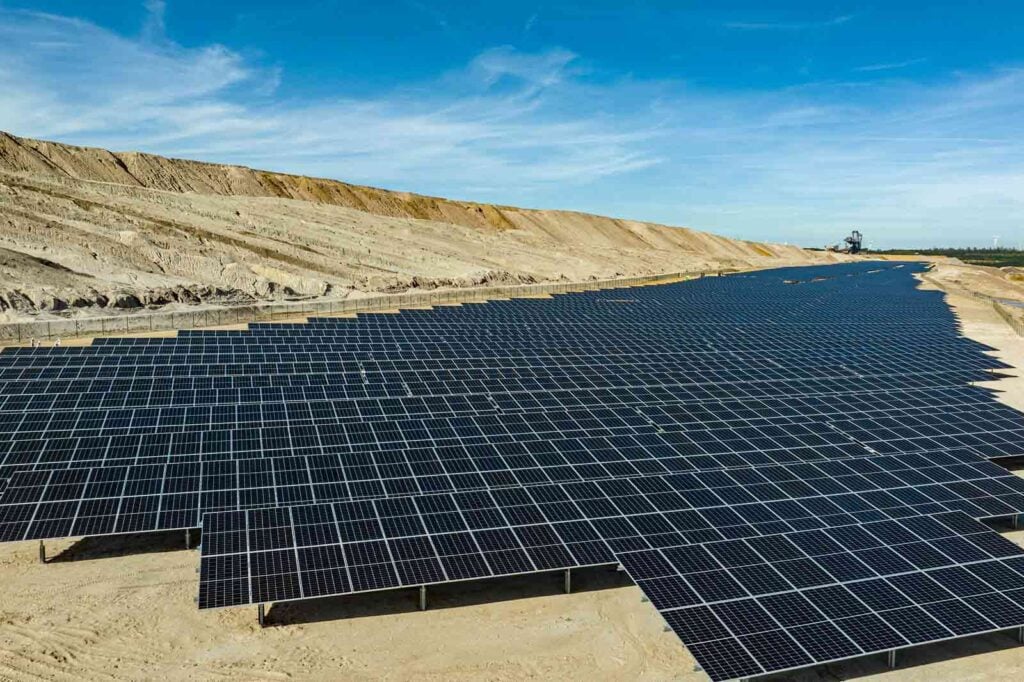Rows of solar PV modules extend into the background at a former open-cast mine site in Hambach, Germany.
