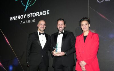 Semih Oztreves collects his Outstanding Contribution trophy at the Energy Storage Awards 2024 from Fabrizio Fenu of EDF and comedian Jen Brister. Image: Solar Media