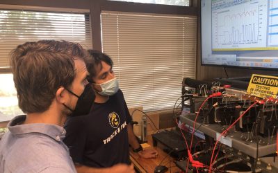 Austin Leach (left) of TechLink is shown test results for Enzinc's nickel-zinc pouch cell by battery engineering intern Santiago Edinger. Image: Enzinc.